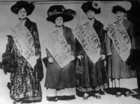 Four women strikers wear Picket, Ladies Tailors Strikers signs as they march in the cold streets