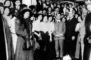 Isaac Harris (hands folded), and Max Blanck surrounded by garment workers.